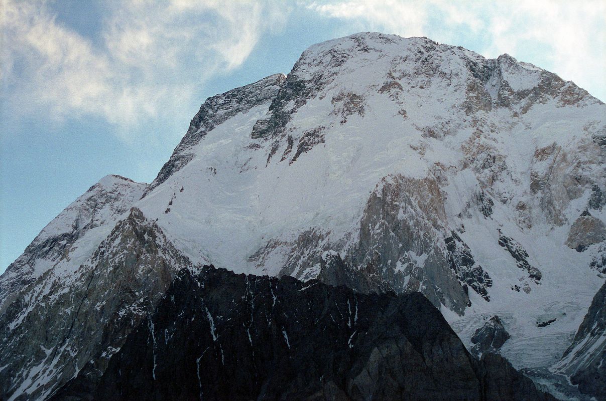 30 Broad Peak North Summit, Central Summit And Main Summit Just After Sunrise From Concordia The three summits of Broad Peak are seen at sunrise from Concordia. The North Summit is on the far left, the Central Summit is in the middle with just a touch of sun, and on the far right is the Main Summit. The first ascent of Broad Peak was completed by Marcus Schmuck, Fritz Wintersteller, Kurt Diemberger, and Hermann Buhl on June 9, 1957. This extremely small expedition marked a major step forward in the development of Himalayan climbing. Diemberger: [Buhl's] plan was that from base camp onwards there would only be climbers on the mountain; they would do everything, load-carrying, establishment of camps and, finally, the assault on the summit. And it was all to be done without the use of oxygen. Diemberger reached the summit just as Marcus Schmuck and Fritz Wintersteller started their descent. As Diemberger was descending from the summit he met Buhl still ascending. Slowly, with all that incredible strength of his will, he started to move, very slowly, upwards. ... Two men were standing on a peak, still breathing heavily from the ascent, their limbs weary - but they did not notice it; for the all-enveloping glory of the sun's low light had encompassed them too. Deeper and deeper grew the colours. ... No dream-picture, this. It was real enough, and it happened on the 26,404-foot summit of Broad Peak.  Summits And Secrets by Kurt Diemberger.